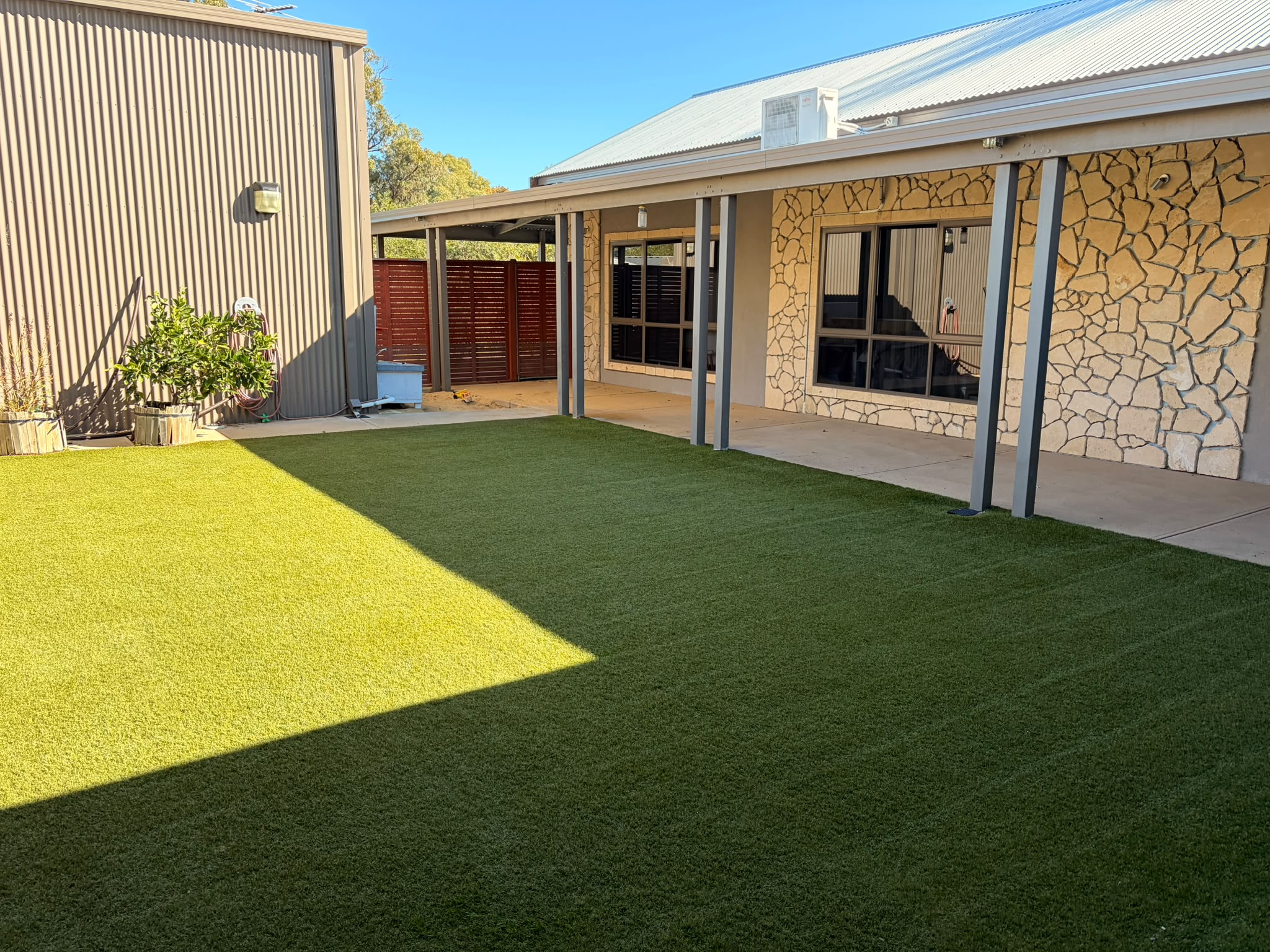 Lush, freshly cleaned artificial turf in a Perth backyard after the 4-stage treatment
