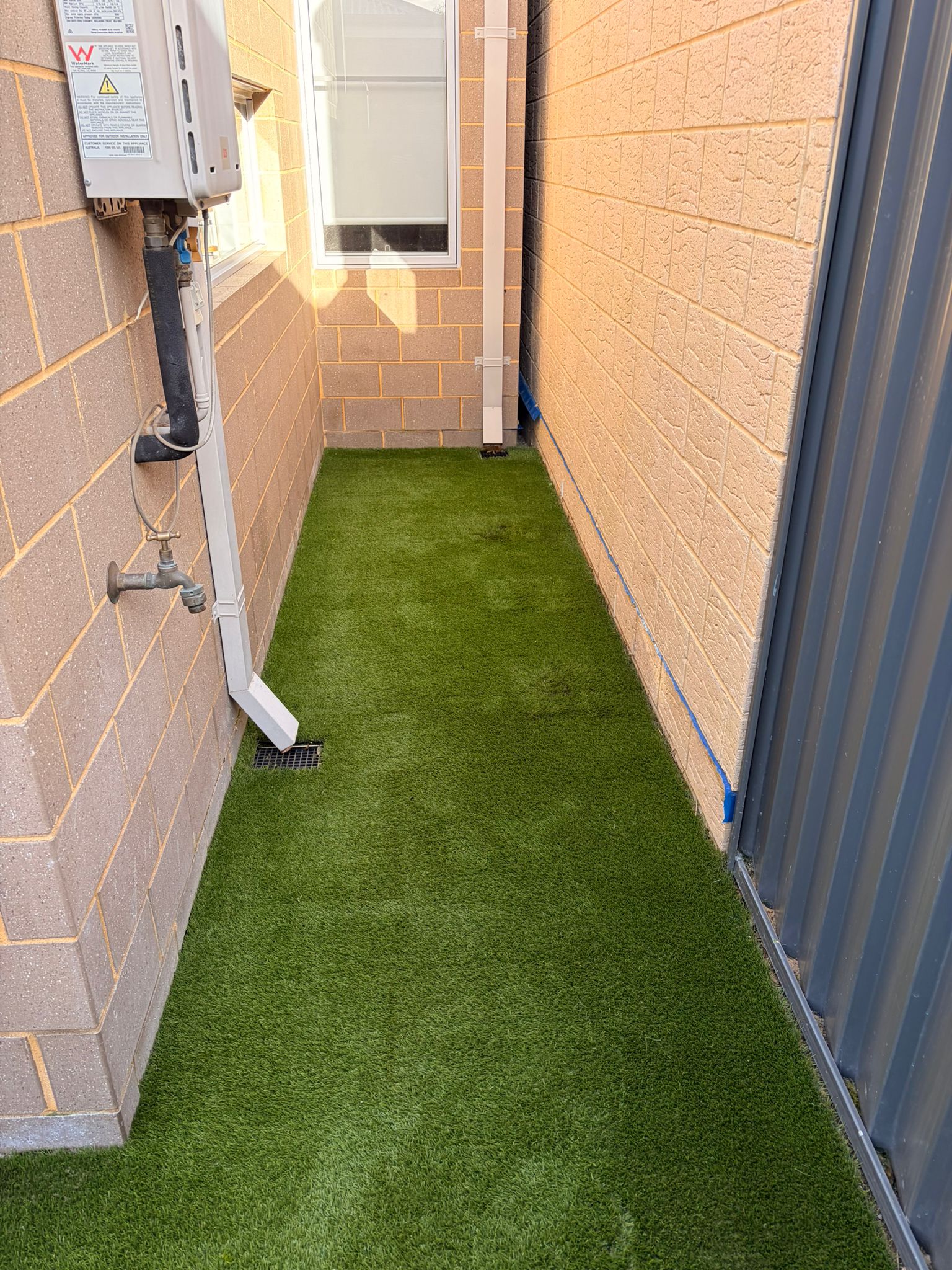 The same Atwell side-return turf strip after the 4-stage Roll&Comb clean, pile lifted and colour evened out in the evening light
